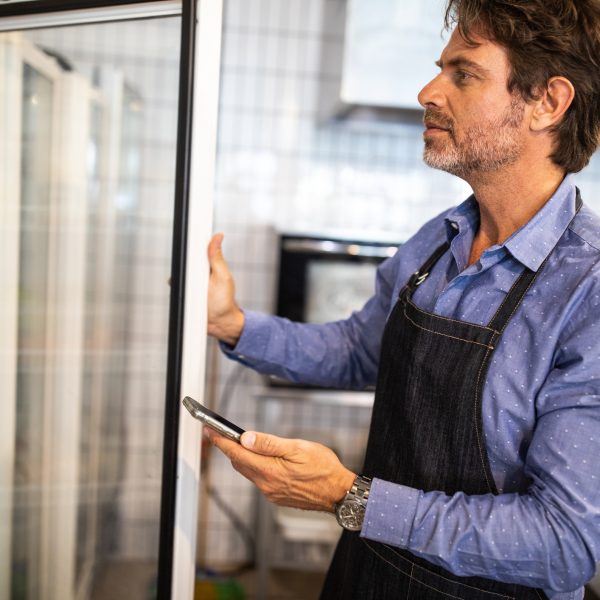 man reaching into a reach in refrigerator, wishing it was a walk in refrigerator